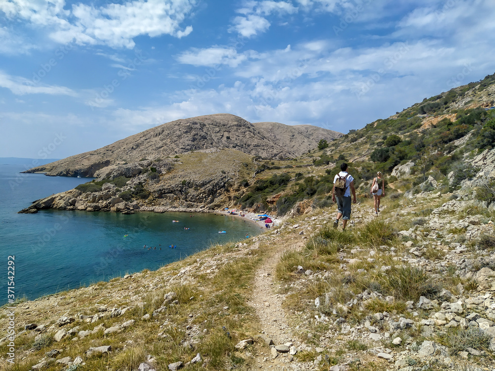 male and female young tourist walking towards Oprna bay in Stara Baska, island Krk, Croatia male and female young tourist walking towards Oprna bay in Stara Baska, island Krk, Croatia