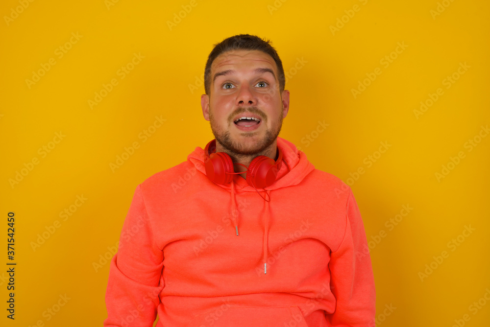 People and sudden reaction concept. Surprised caucasian handsome male student, shrugs shoulders, looking sideways, being happy and excited about new plans with friends. Isolated over gray wall. People and sudden reaction concept. Surprised caucasian handsome male student, shrugs shoulders, looking sideways, being happy and excited about new plans with friends. Isolated over gray wall.