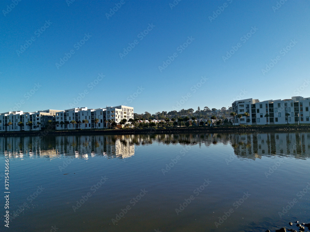 Beautiful view of a river with reflections of modern apartment buildings, deep blue sky and trees on water, Parramatta river, Wilson Park, Silverwater, Sydney, New South Wales, Australia
