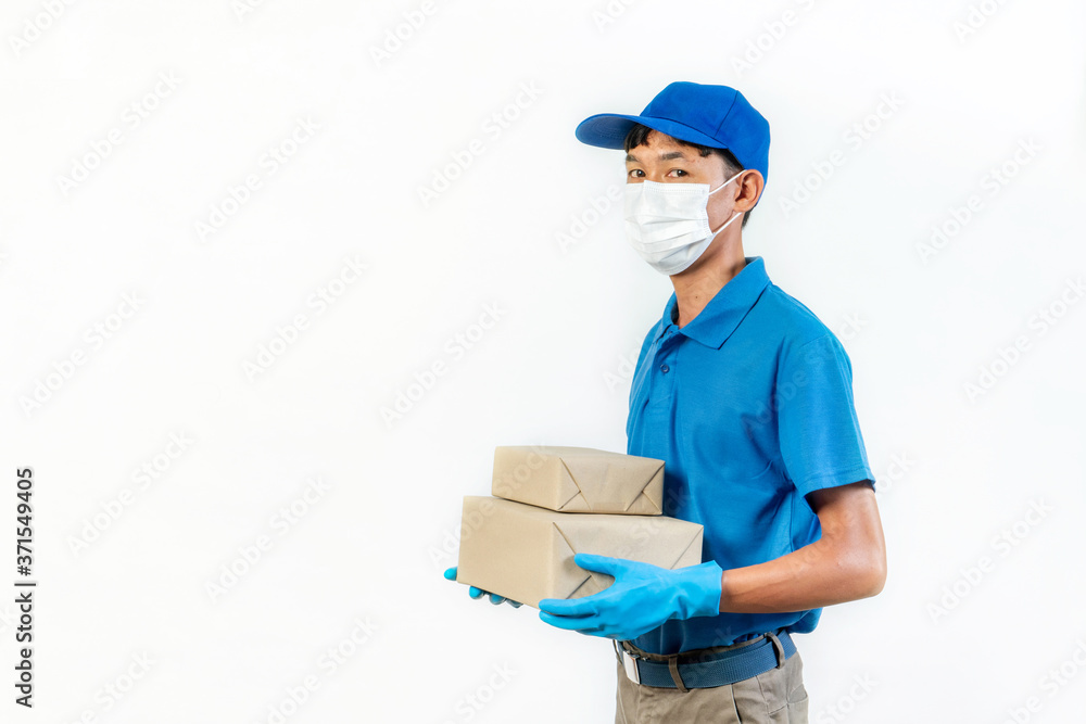 Delivery man in medical safety mask holding and carrying a card box isolated on white background. Buy food online in the quarantine period. Delivery man in medical safety mask holding and carrying a card box isolated on white background. Buy food online in the quarantine period.