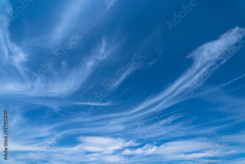 Blue cloudy sky with white cirrus clouds. Soft focus photo