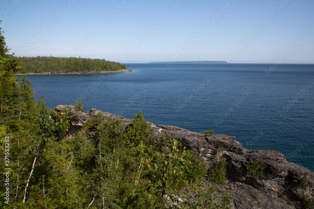 Blue water and rocky forested shoreline of  georgian Bay along Bruce Peninsula trail