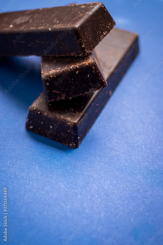 Fresh and sweet chocolate bars on a blue surface Fresh and sweet chocolate bars on a blue surface