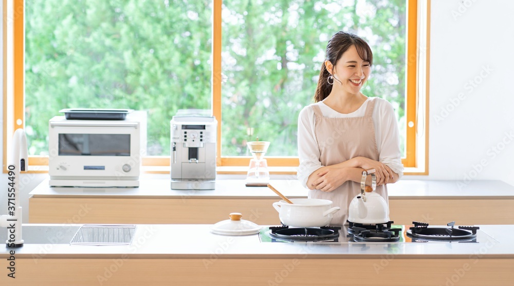 キッチンに立つエプロン姿の女性 Stock Photo Adobe Stock