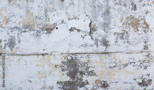 wall texture with old white plaster that has cracked and fallen off