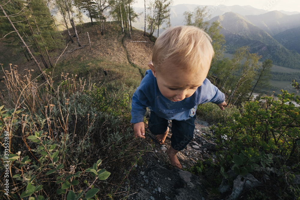 Funny Boy kid barefoot hiking and walking in mountains with beautiful valley view Funny Boy kid barefoot hiking and walking in mountains with beautiful valley view