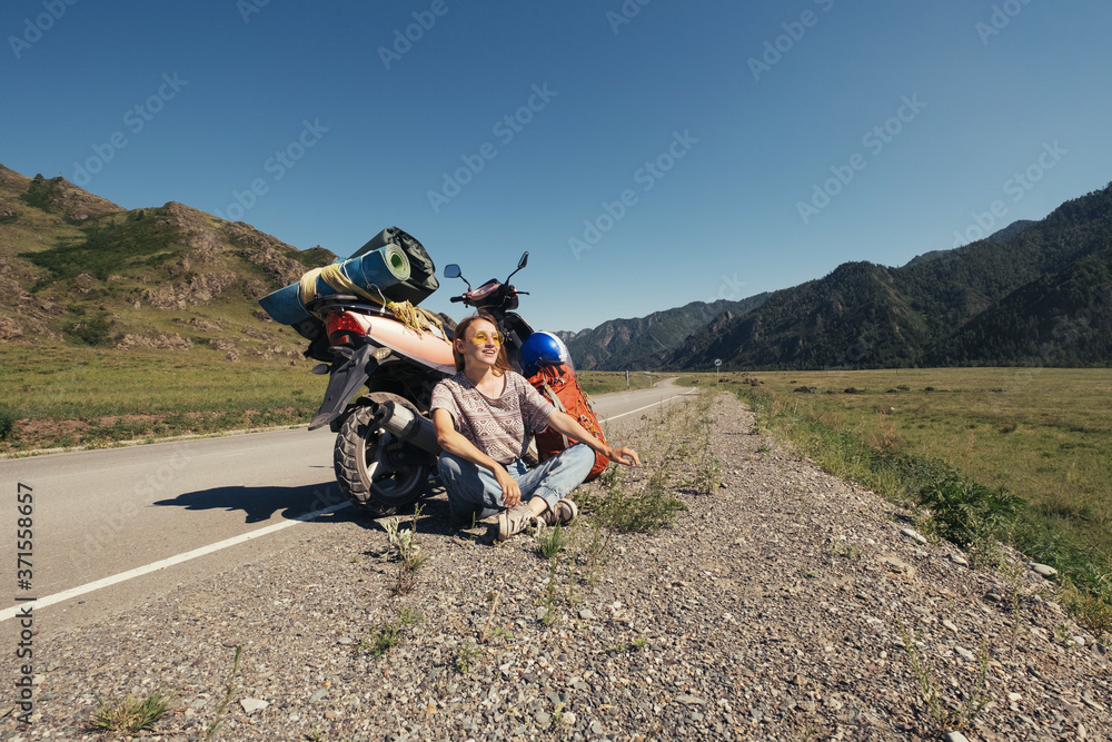 Young woman travelling by scooter in mountains road Young woman travelling by scooter in mountains road