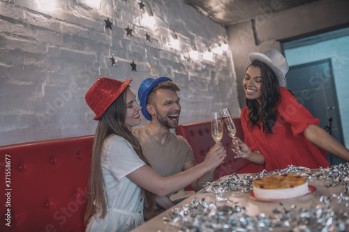 Cheerful young friends celebrating a birthday with champagne