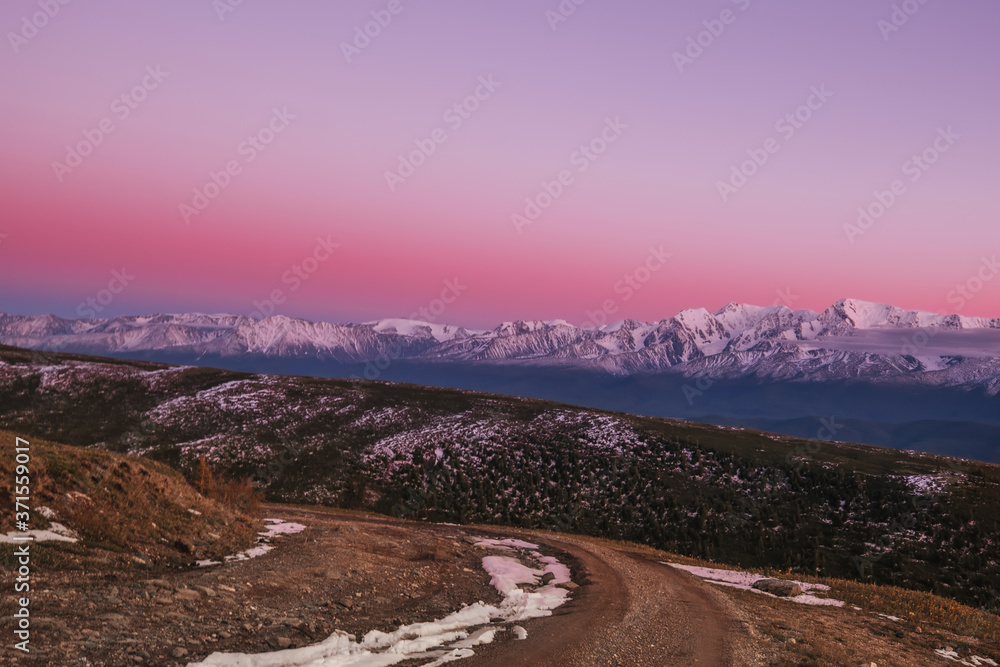 Pink sunset over the North Chuysky ridge, amazing mountain landscape with snow peaks