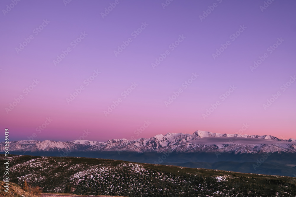 Pink sunset over the North Chuysky ridge, amazing mountain landscape with snow peaks