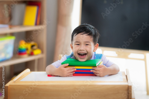 Photography Asian student happy after back to school and smile in his class room in preschoo