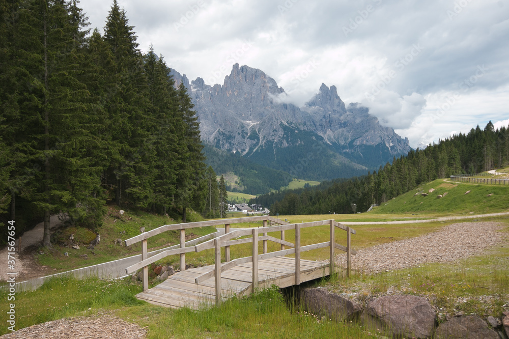 Panoramic view of little wooden bridge and Pale di San Martino in San Martino di Castrozza, Trentino