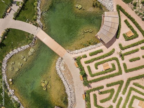 Drone aerial top view of lake in park with the bushes labyrinth.