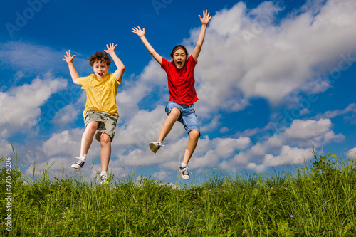 Girl and boy running, jumping outdoor 
