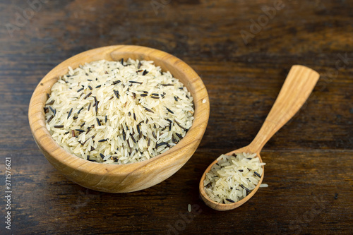 Wild rice in a wooden bowl on a wooden table.