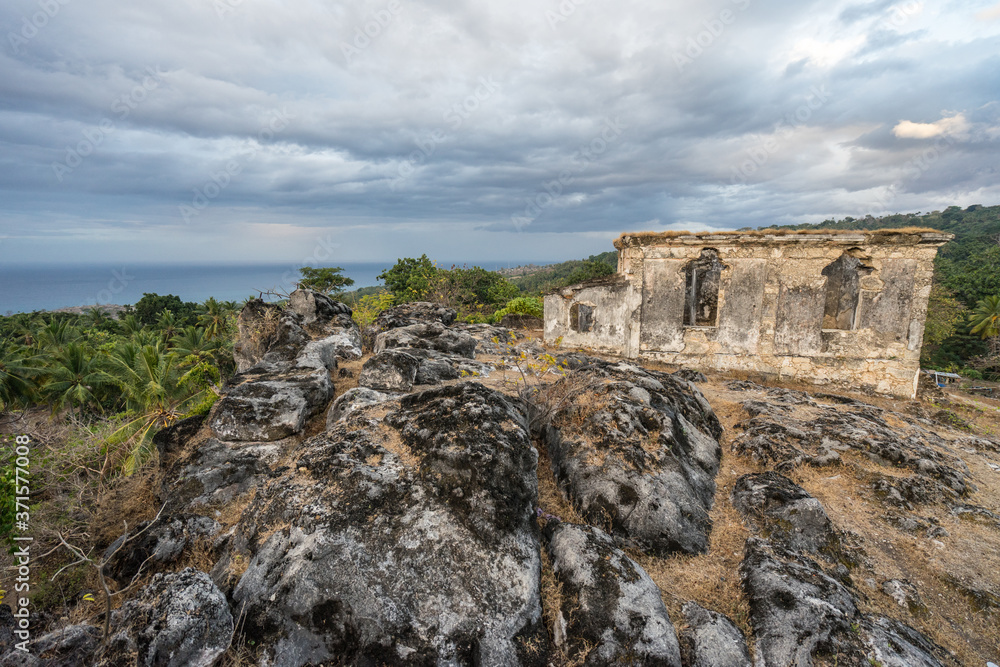 colonial style house collapsed with the sea in the background