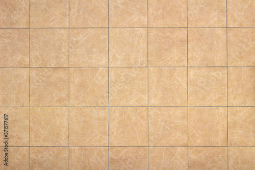Photo of a wall covered with khaki tiles as background material
