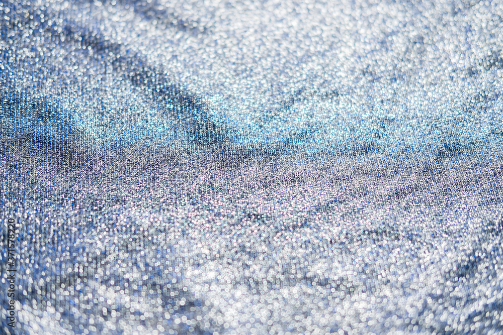 Obraz premium Shiny fabric texture. Silver sparkling background. Clothing piece of glitter metallic for a glamorous party, celebration. Close-up.
