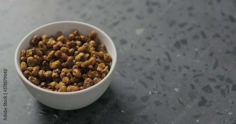 Slow motion handheld shot of dried seaberry in white bowl on terrazzo countertop Slow motion handheld shot of dried seaberry in white bowl on terrazzo countertop