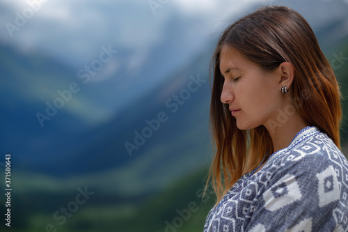 Stylish female hipster walking on top of mountains.
