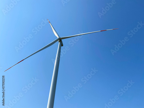 Detail of a wind turbine with a blue sky, wind turbine generating electricity on blue sky, Sustainable development, renewable energy and Wind turbines generating electricity © tolgahan