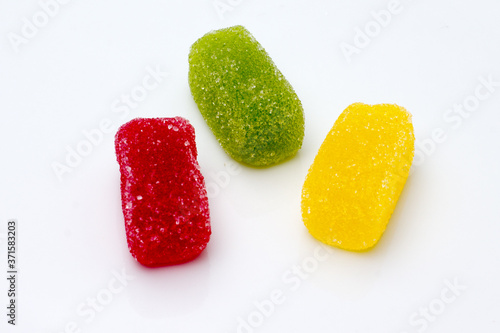 Red, green and yellow jelly beans with lollipop, apple and lemon flavors.