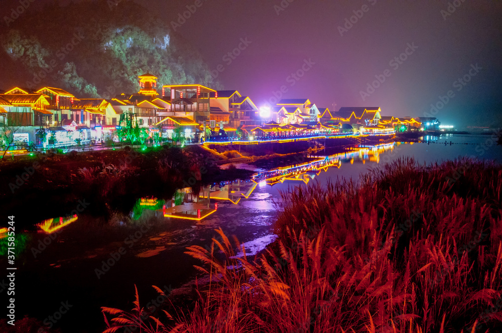 Night scene of Xibu Street, Zhangjiajie, Hunan, ,with stilted buildings, ancient buildings, streets, rivers and lights, orange sky and reflection as the background, brilliant effect, concept of: gorge
