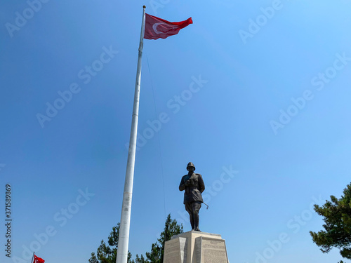 Turkish flag and Mustafa Kemal Ataturk statue under the blue sky
