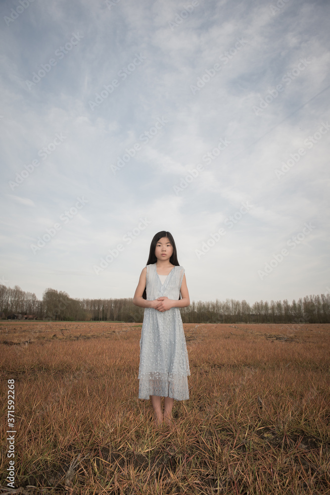Young girl in a field in light blue dress Young girl in a field in light blue dress
