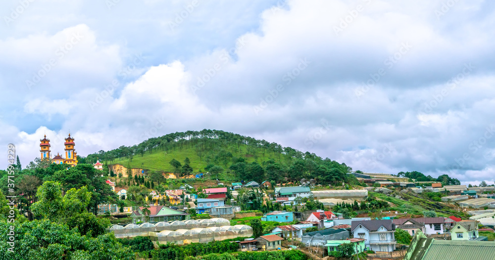Fototapeta premium Small town on a stormy morning with moving clouds on the top of the hill and the valley is the peaceful in Da Lat, Vietnam