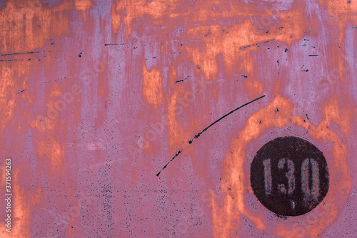 The old iron background is painted yellow, orange, purple, red in with rust and chips