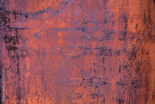 The old iron background is painted yellow, orange, purple, red in with rust and chips