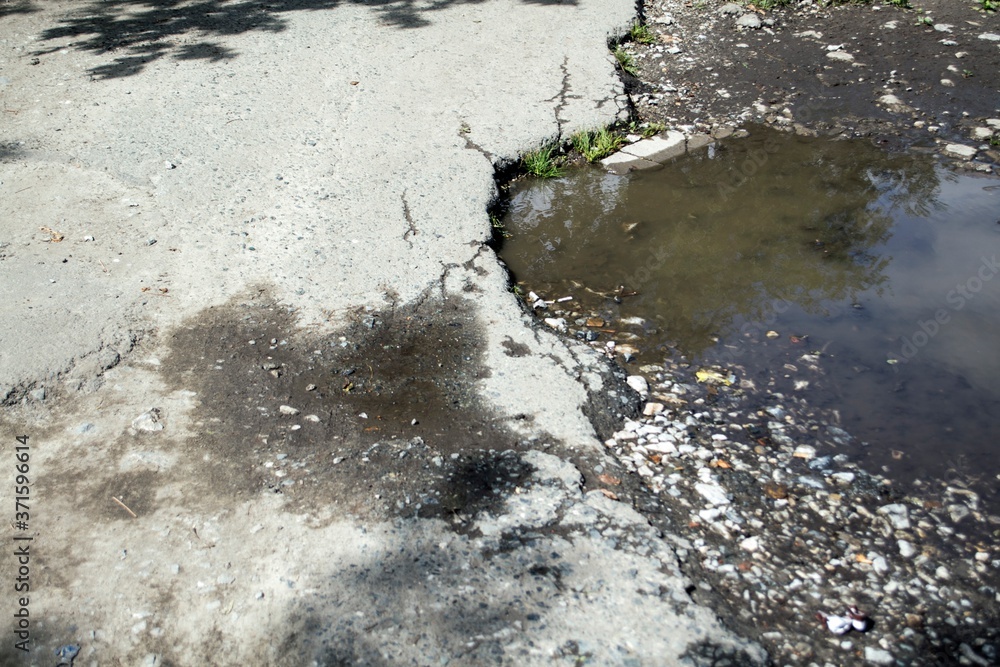 Cracked asphalt and a puddle. Cracked asphalt and a puddle.