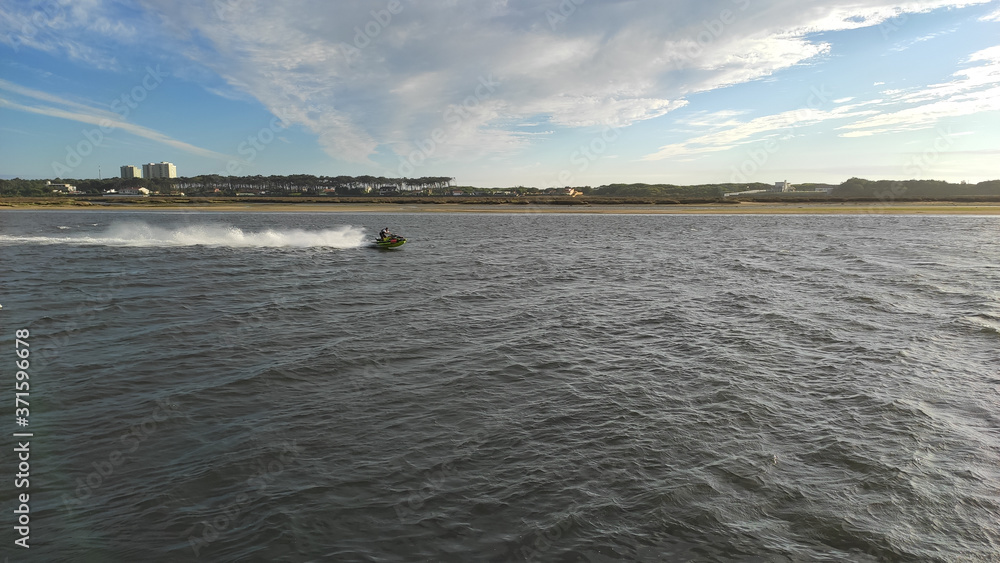 Man on Jet Ski having fun in the mouth of the Cavado River in Esposende, Portugal. The large estuary of the Cávado river.