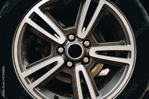 Close-up of a dirty metal alloy wheel on a car.