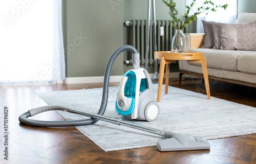 Vacuum cleaner in living room at home photo