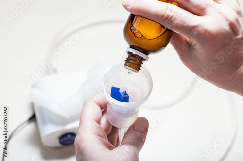 dripping solution from vial into nebulizer photo