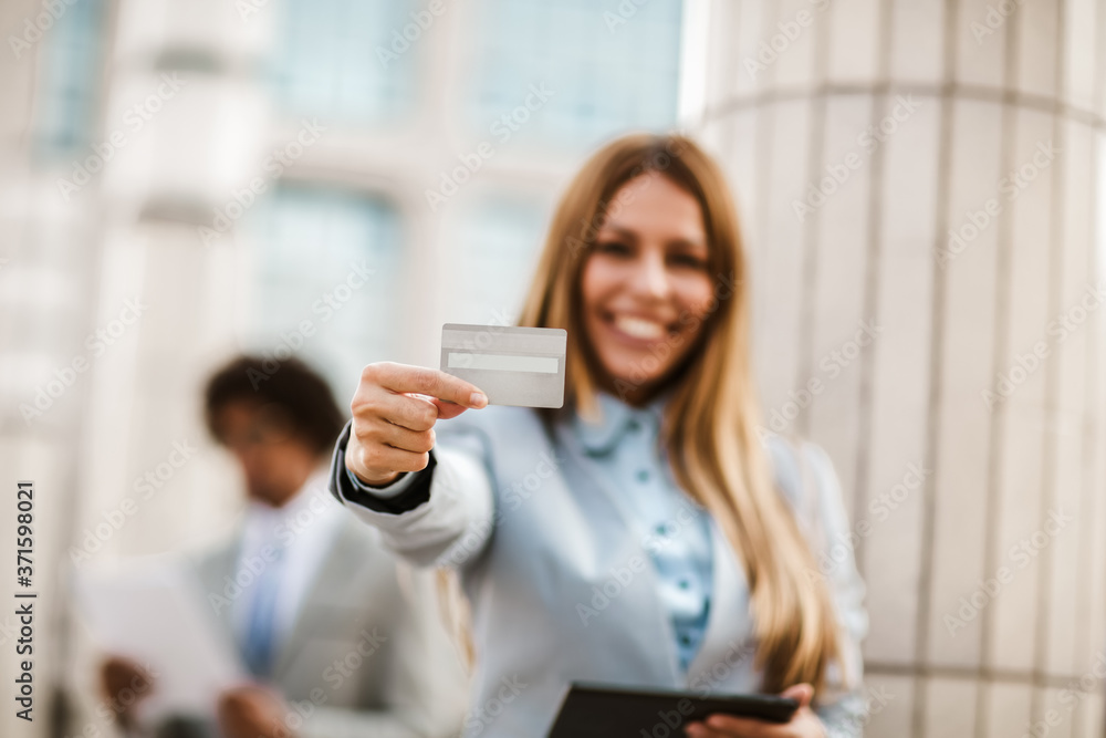 Portrait of businesswoman smiling outdoor holding credit card and digital tablet. Portrait of businesswoman smiling outdoor holding credit card and digital tablet.