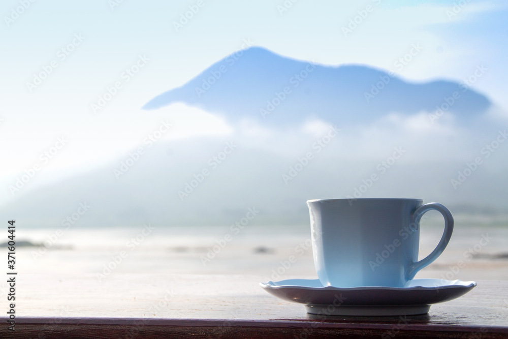 White coffee cup on mountain background in the morning near the river