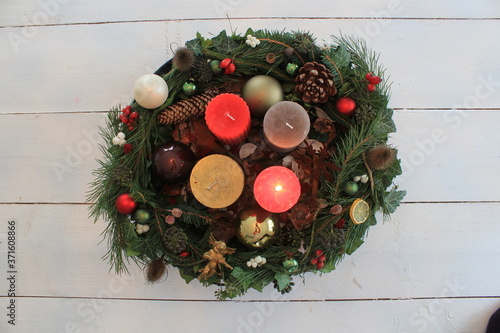  christmas wreath with one burning candle on a white table