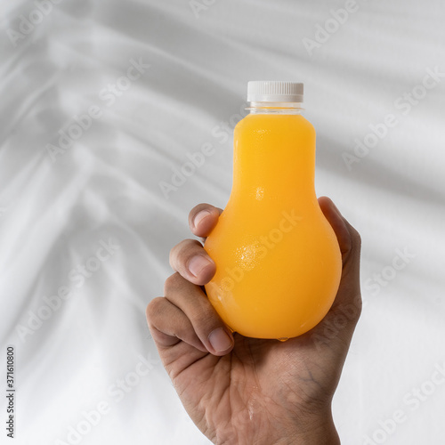 hand holding fruit juice on a plastic bottle product mockup