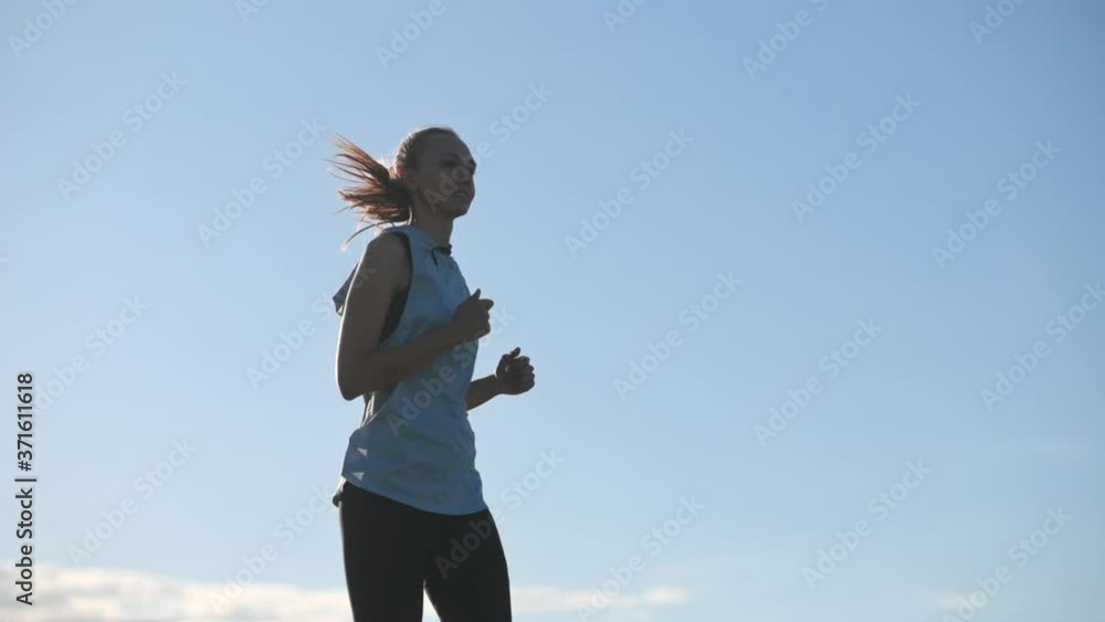 Young fit girl in sportswear is working out outdoors. Jogging in the park at sunset. Healthy and sport lifestyle. SLOW MOTION Young fit girl in sportswear is working out outdoors. Jogging in the park at sunset. Healthy and sport lifestyle. SLOW MOTION