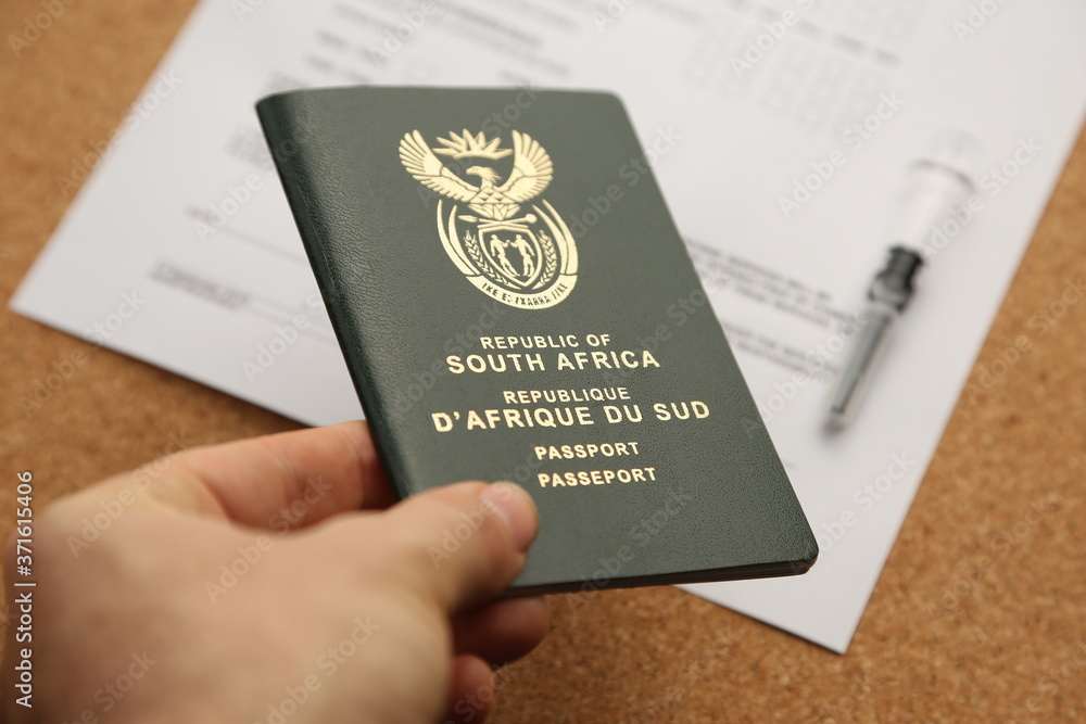 Travelling during the Covid-19 pandemic concept photo consisting of a vaccine syringe on top of a South African passport with an immunization certificate. This photo has selective focus. Travelling during the Covid-19 pandemic concept photo consisting of a vaccine syringe on top of a South African passport with an immunization certificate. This photo has selective focus.