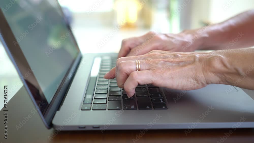 close up view of senior woman typing on keyboard of computer send email. technology concept close up view of senior woman typing on keyboard of computer send email. technology concept