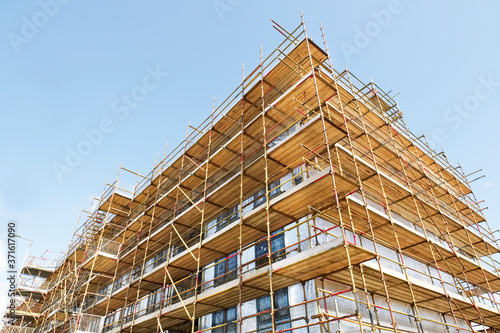 Fototapeta Scaffolding surrounding house development for safe access to construction work