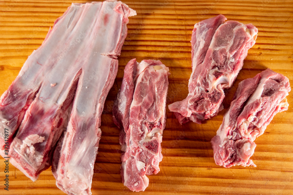 
Mutton ribs, raw, on a wooden cutting board