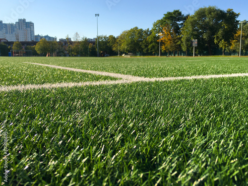 School stadium. Green grass soccer field with white markings. © vladzelinski