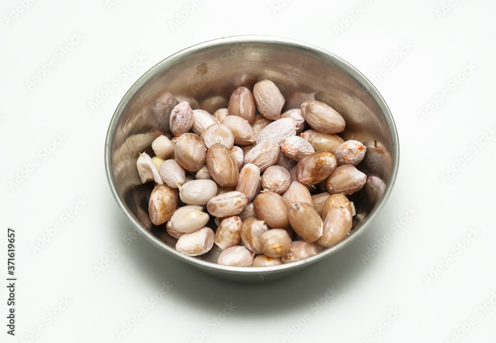 Peanuts in a silver bowl on a white background Peanuts in a silver bowl on a white background