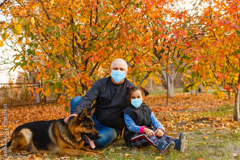 grandfather and granddaughter wearing face mask during coronavirus outbreak. Virus spread flu prevention carantine. stay safe. stop covid 19. autumn background