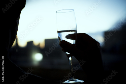 Silhouette of glass with champagne held by a hand